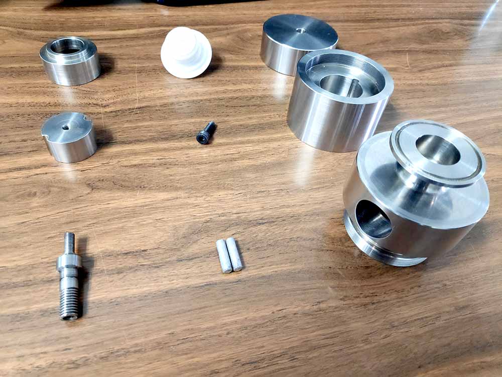 Conjunto de componentes metálicos mecanizados en CNC, piezas de precisión listas para montaje de sistema mecánico.