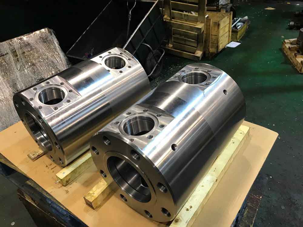 Cuerpos cilíndricos mecanizados en CNC de gran tamaño con bridas y alojamientos, componentes industriales de alta precisión.