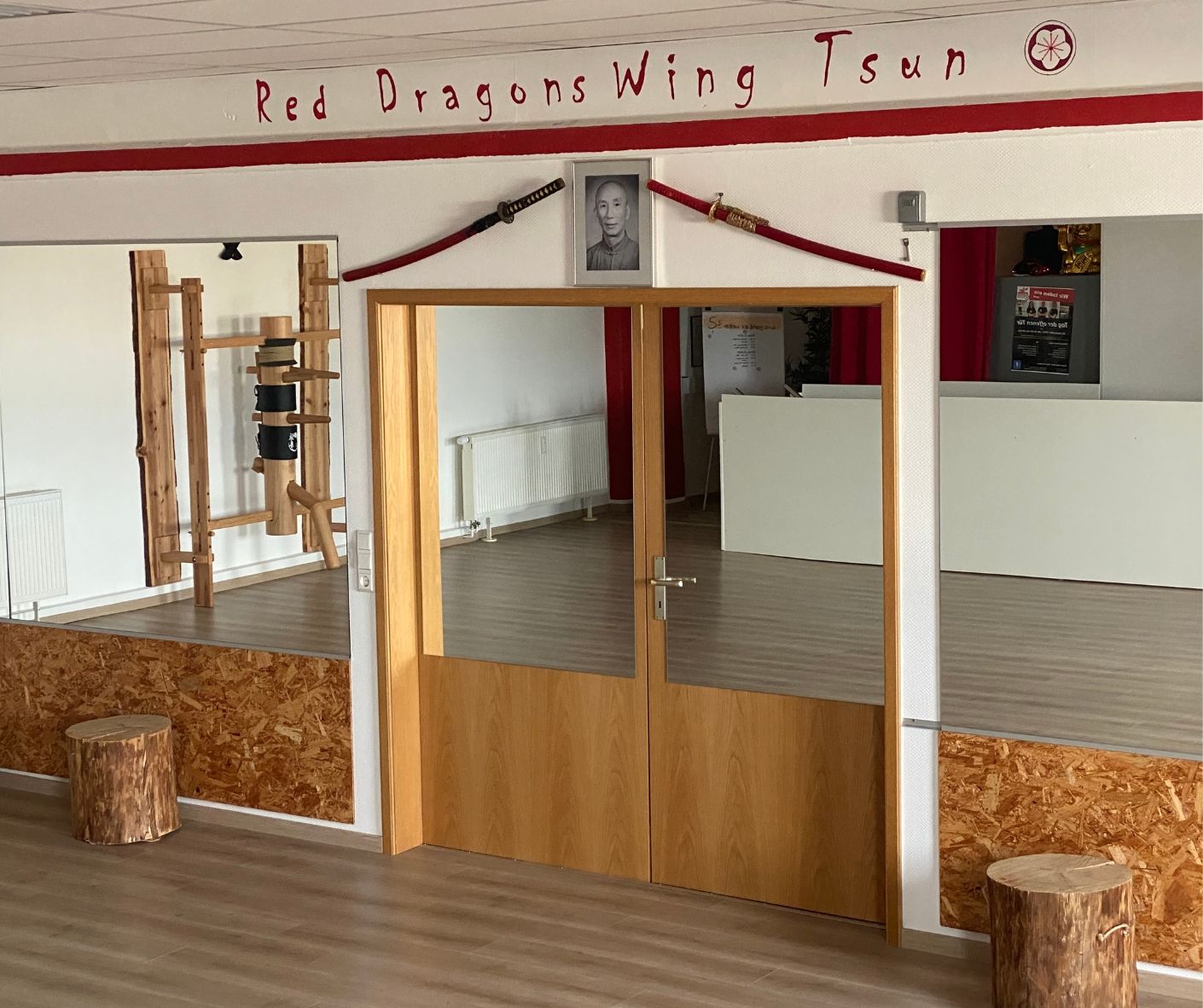Doppeltür, verspiegelt, darüber steht auf der Wand Red Dragons Wing Tsun.