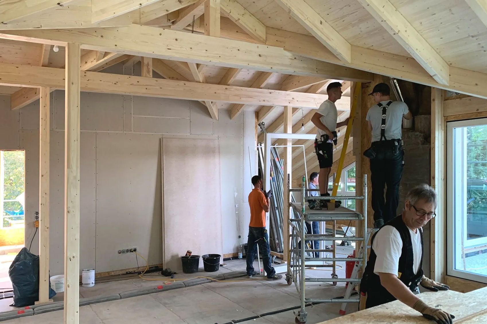 Arbeiter arbeiten in einem Rohbau aus Holz