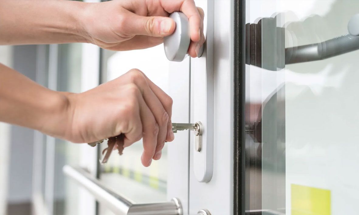 Eine Person schließt eine Haustür mit einem Schlüssel auf