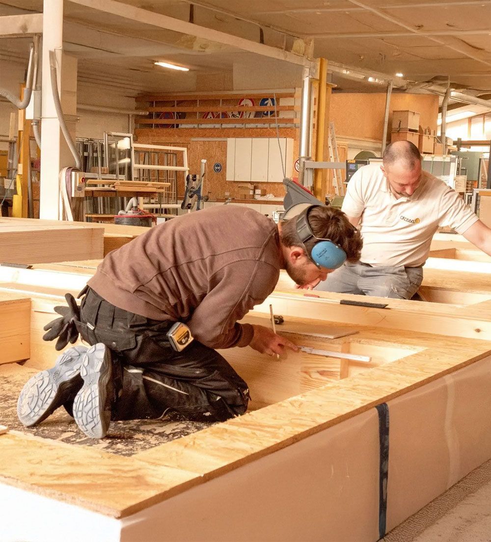 2 Arbeiter von Grübbel arbeiten an einer Holzkonstruktion