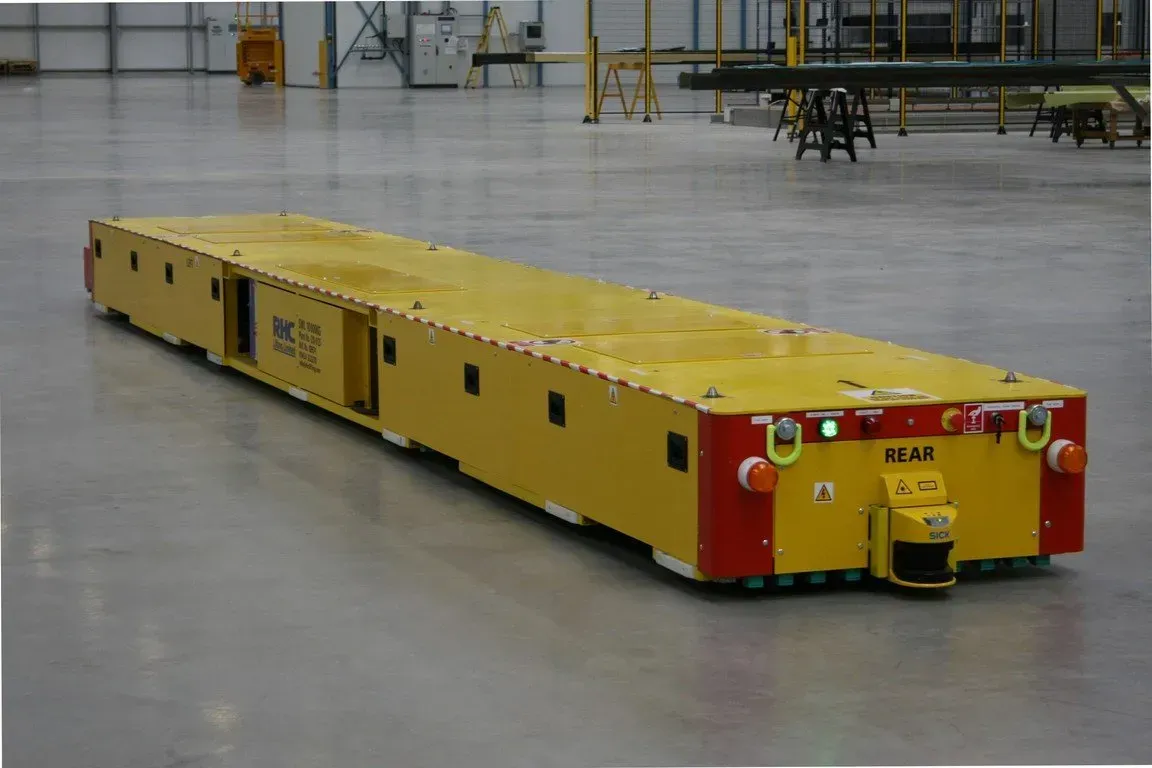 The rear of an automated traveling vehicle, shown moving across a floor