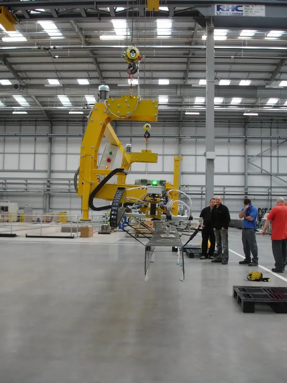 A side on image of a vacuum lifting beam lifting a steel beam