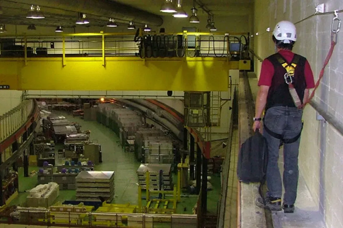 A man working at height using a lifeline system to move across the wall