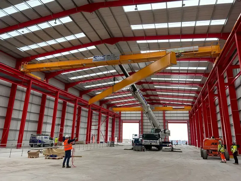 A mobile crane lifting a beam into place