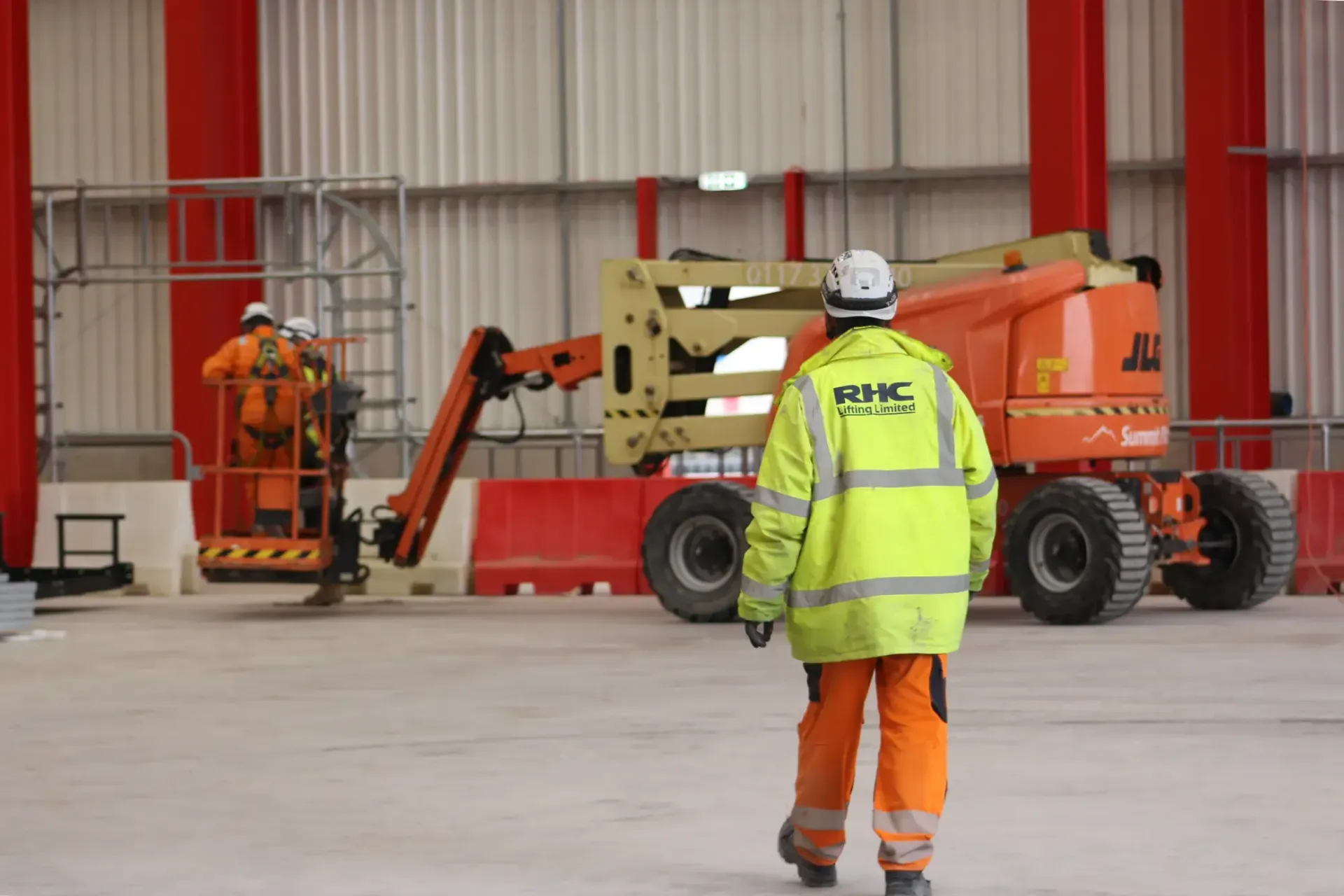 RHC Engineer wearing yellow hi-vis jacket, walking towards a MEWP