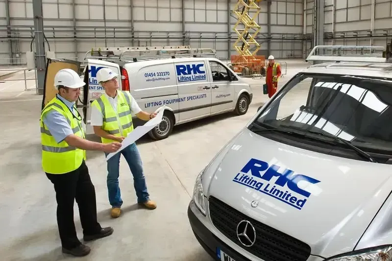 2 RHC Engineers looking at plans whilst on site, stood next to an RHC Lifting van