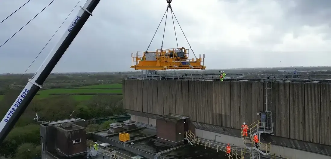 Yellow crane being lifted into a building