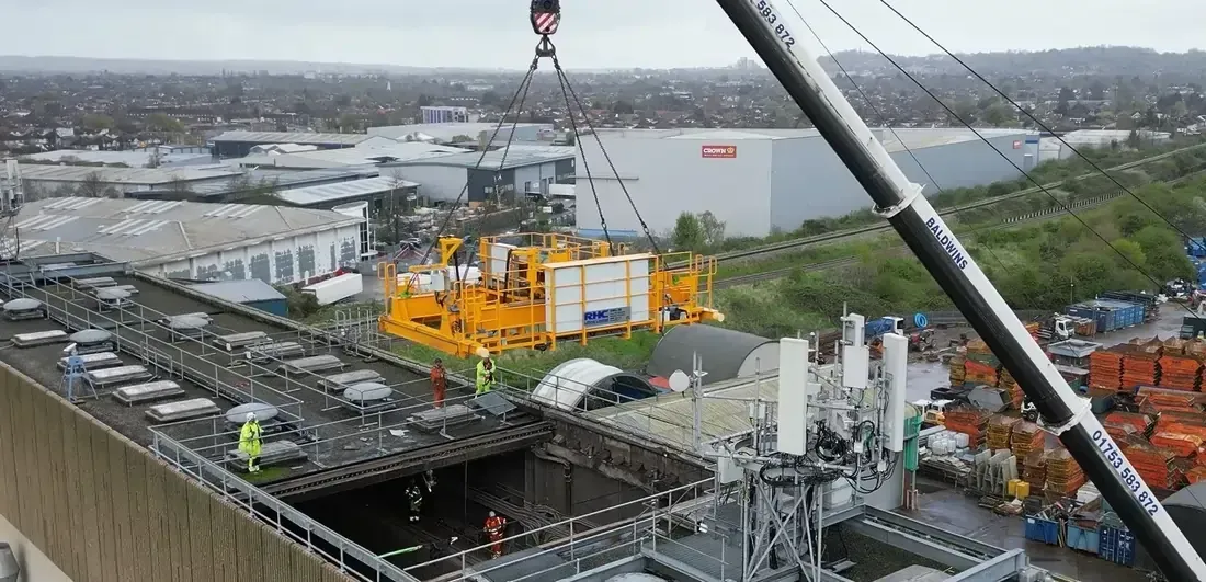 Close up of yellow crane being lifted into a building