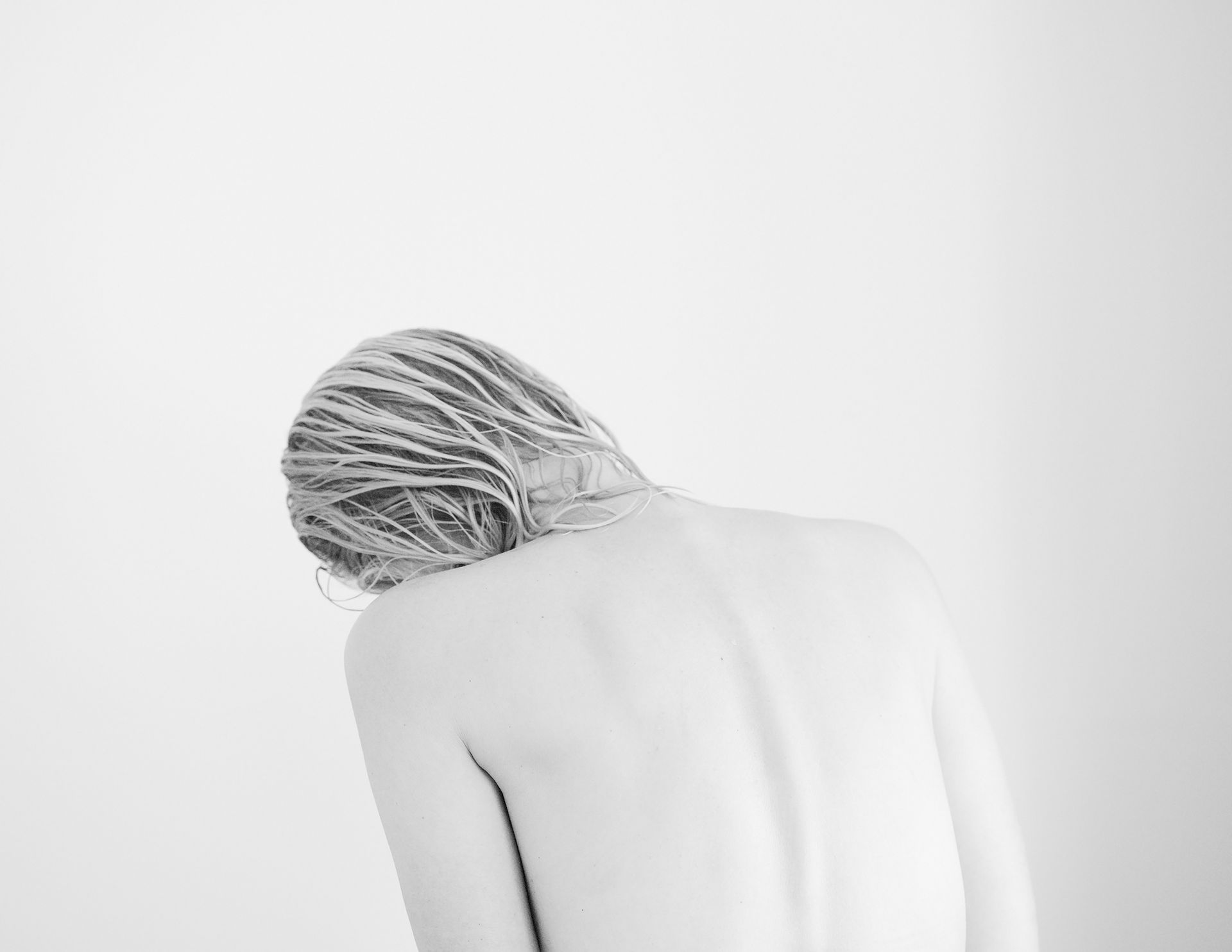 Black and white self-portrait of a woman with wet hair, head tilted to the left, bare back and shoulders visible, simple and natural.
self-portrait, black and white, harmony, minimalism, natural beauty, simplicity, female portrait, contemporary photography, everyday gestures, inner balance