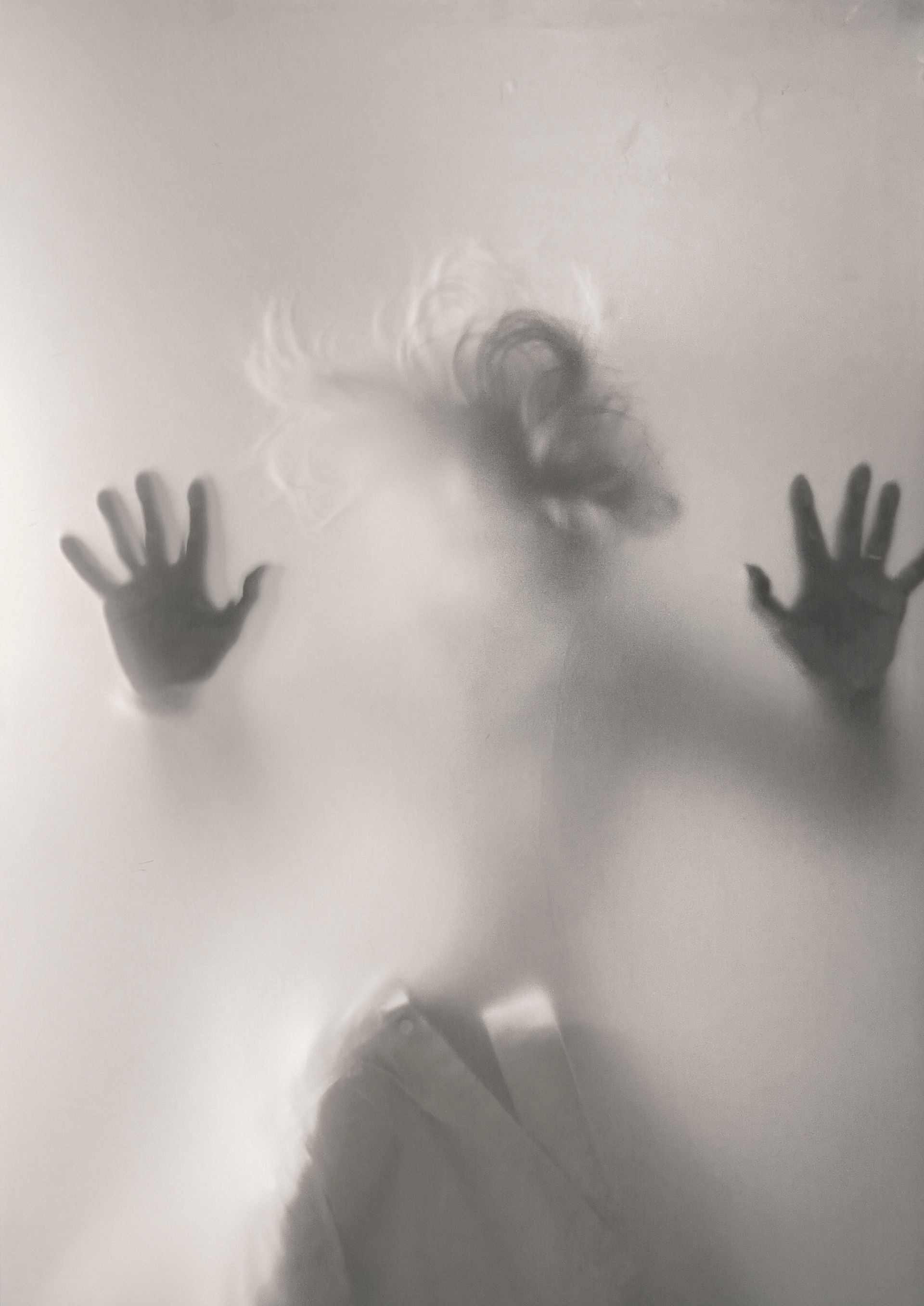 Silhouette in glass Silhouette of a person with raised hands behind frosted glass.