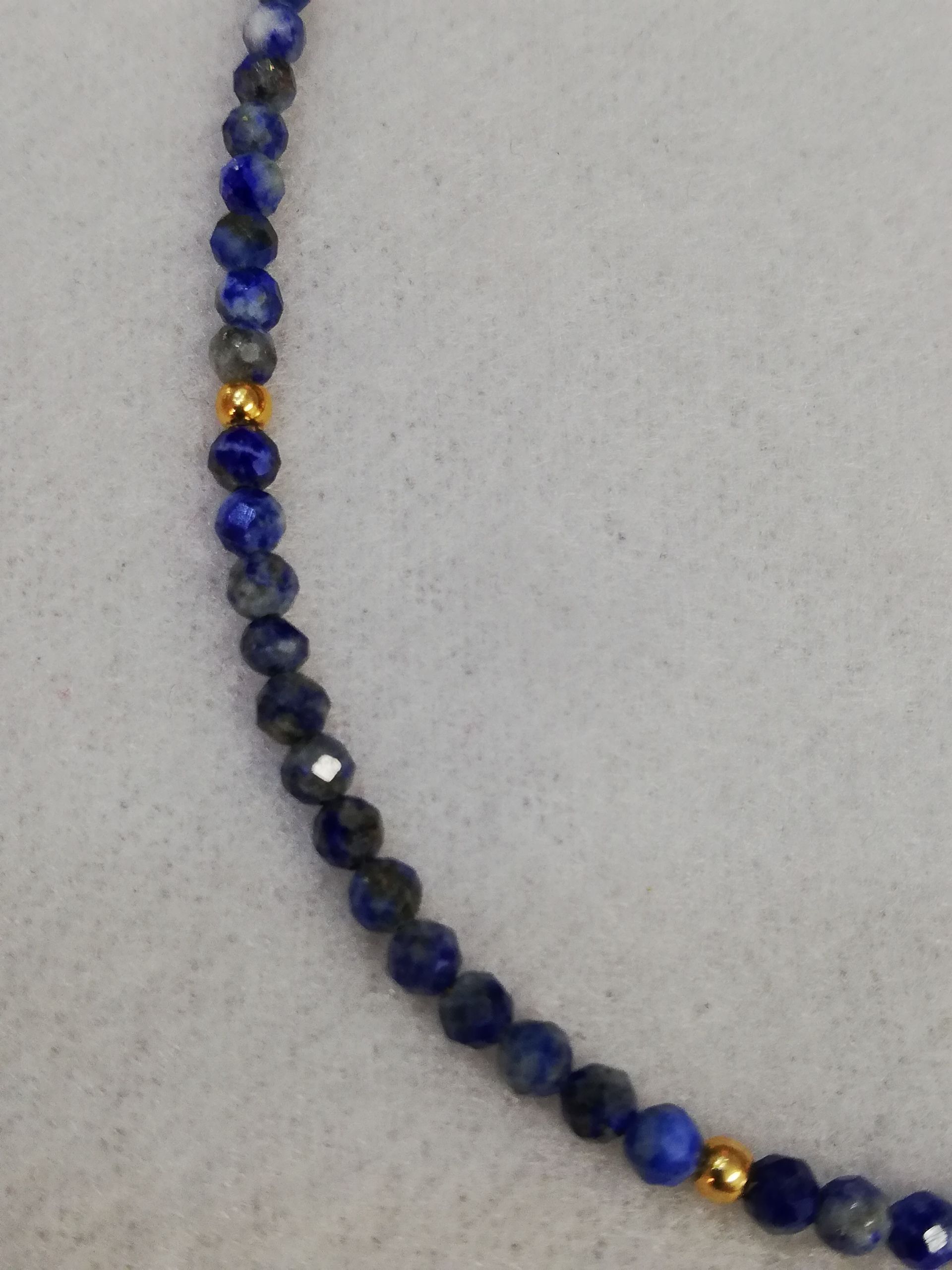 Detail einer Kette: facettierter feiner Lapislazuli mit vergoldeten kleineren Silberkugeln