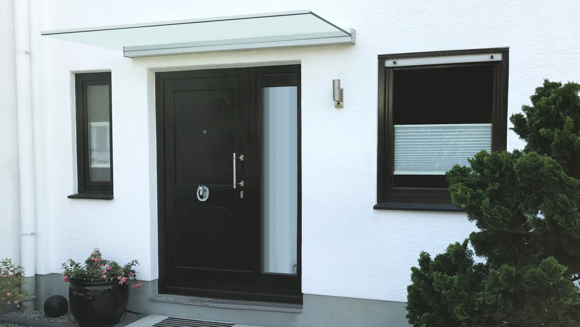 Glas Vordach von Panther Glas bei LS Sonnenschutz in Groß-Umstadt kaufen. Geschützt vor Wind und Regen im Eingangsbereich vor der Haustür. Wir beraten Sie gerne zu verschiedenen Modellen und Farben im Raum Darmstadt, Dieburg, Frankfurt, Aschaffenburg, Odenwald. Panther Glas Vordach ohne Rahmen über Haustür und Eingangsbereich, Link zu Produktseite Vordächer