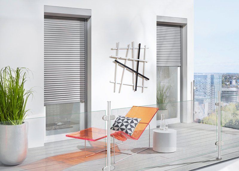 Zwei Terrassentüren mit halb geschlossenen Vorbaurollläden in silber