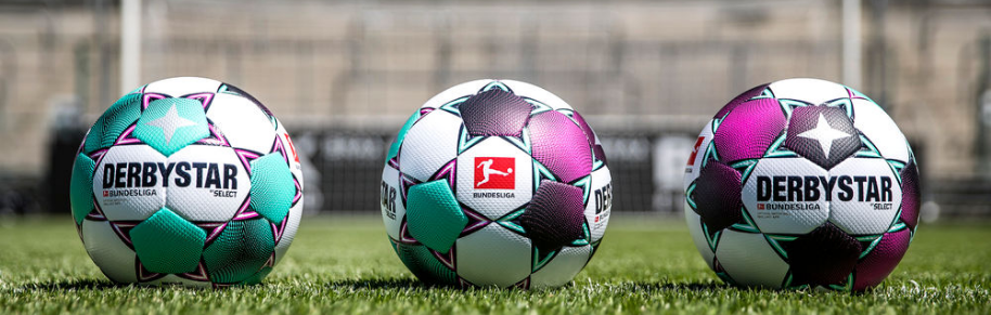 3 Fußbälle nebeneinander auf Rasen