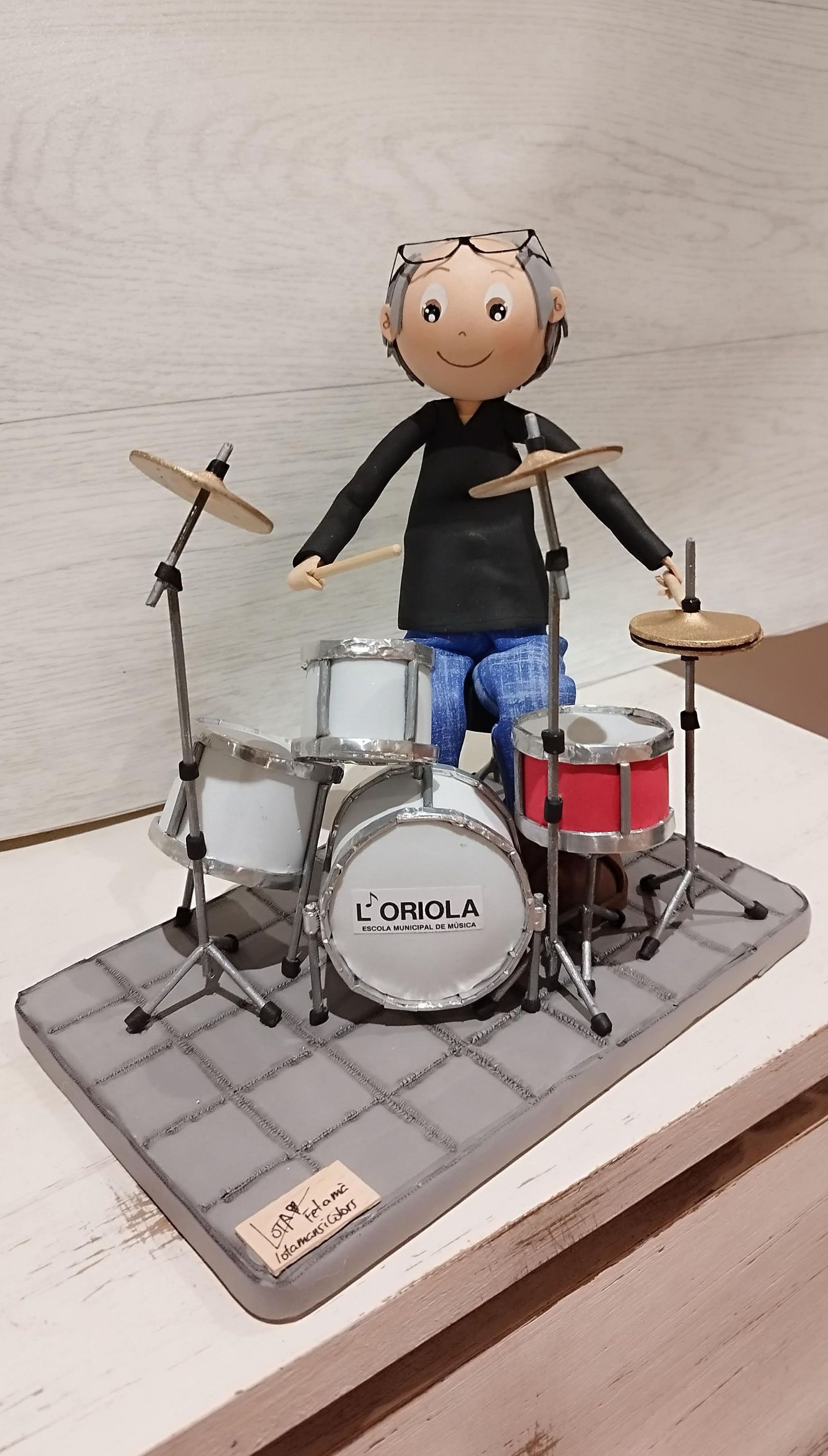 fofucha personalizada tocando la batería, con las gafas en la cabeza, las baquetas en la mano, hecha en goma eva.