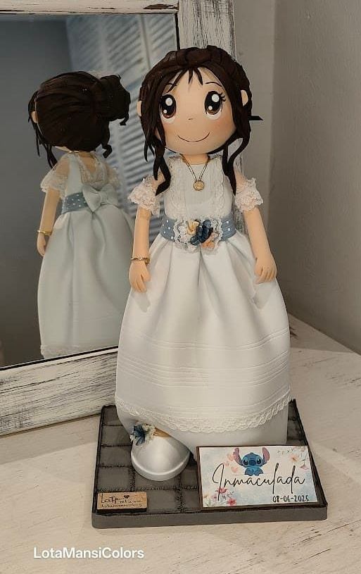 fofuchas personalizadas, para comunión, niña con su vestido blanco con detalles florales en el cinturón y el pelo. Enseña la punta del zapato con flores azules.