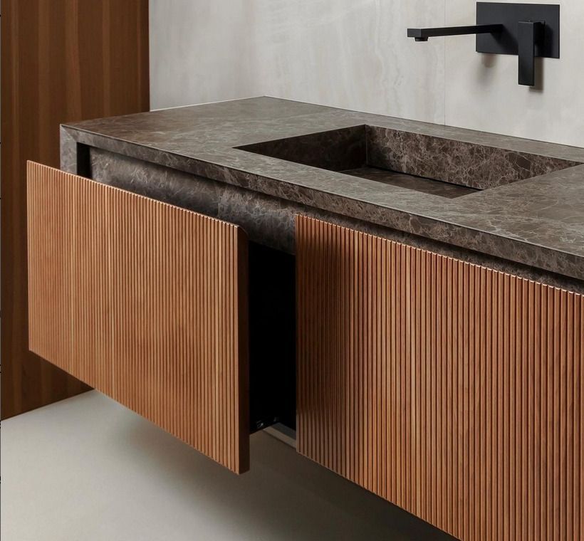 Bespoke cupboards with fluted wood draws and a bespoke marble sink