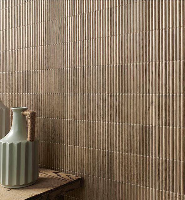 Fluted 3d beige on a wall with a green cup in view