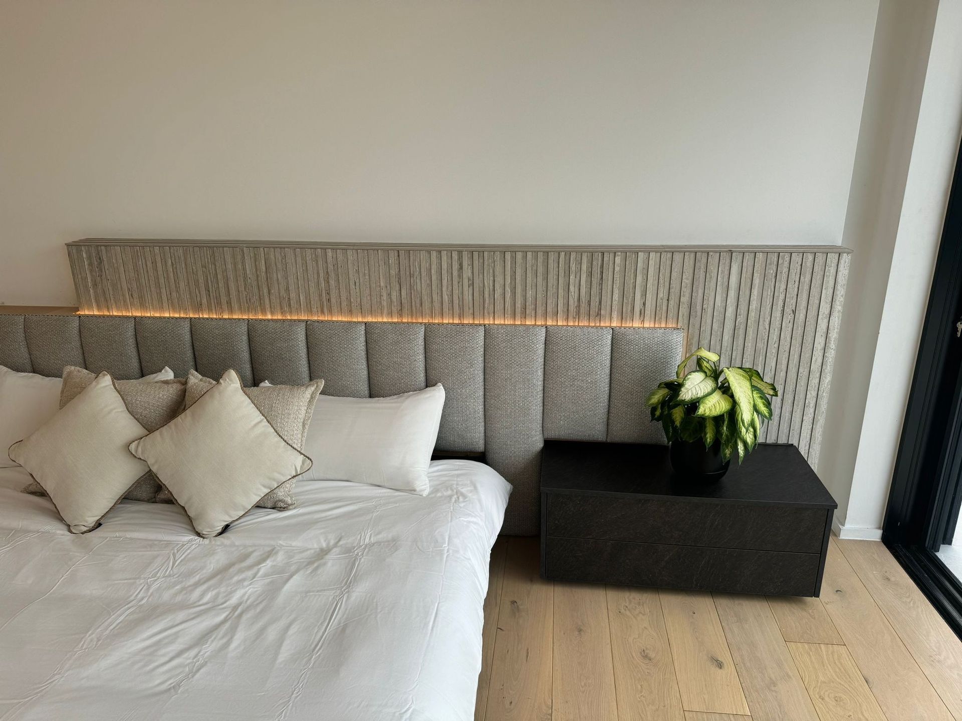Master bedroom with fluted travertine headboard