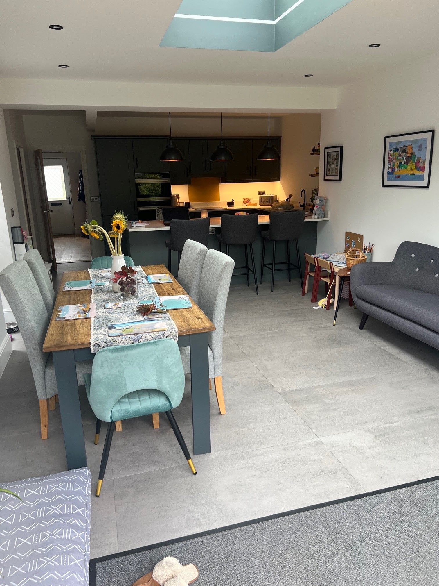 wood table with 4 grey chairs in a kitchen with malvern grey floor tiles
