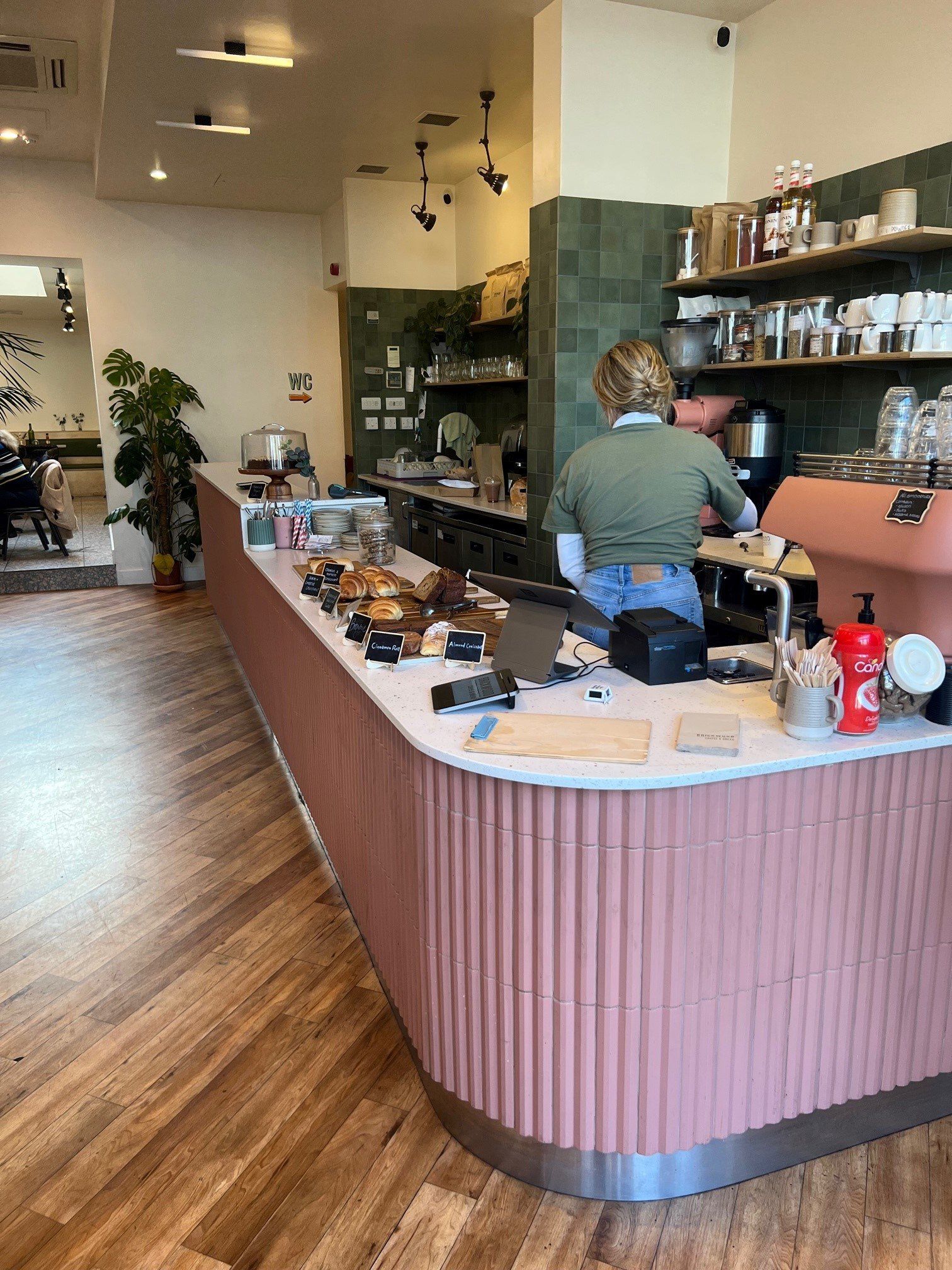 Cafe bar is decorated with fluted rosa tiles and wood effect flooring