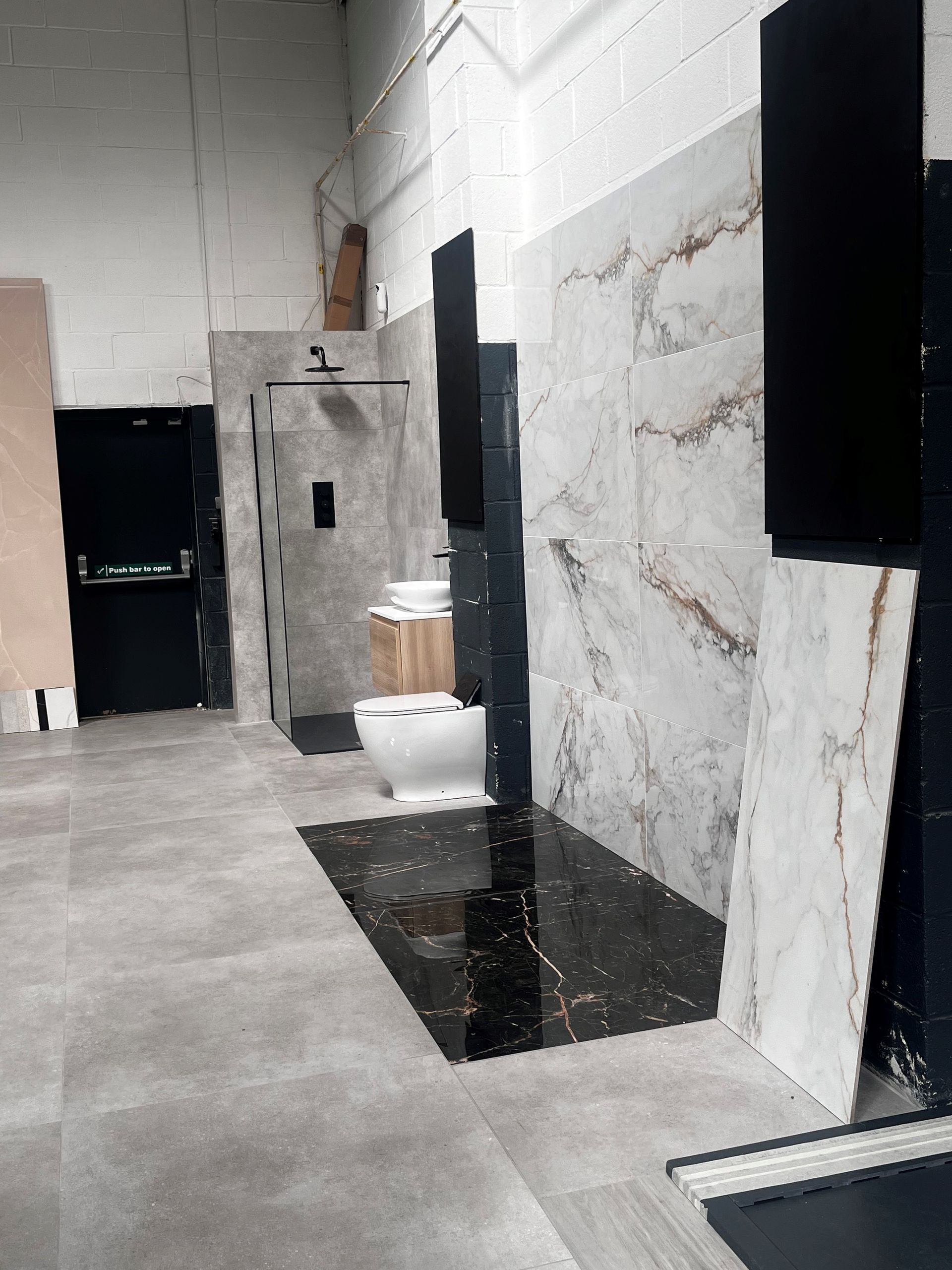 our tile show room with concrete effect floor tiles and marble tiles on the wall