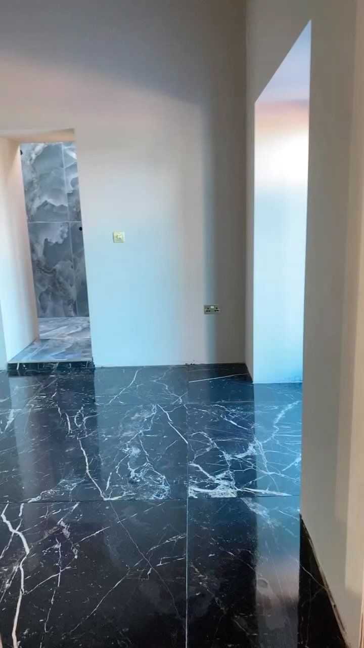 Black marble floor tiles with contrasting white walls