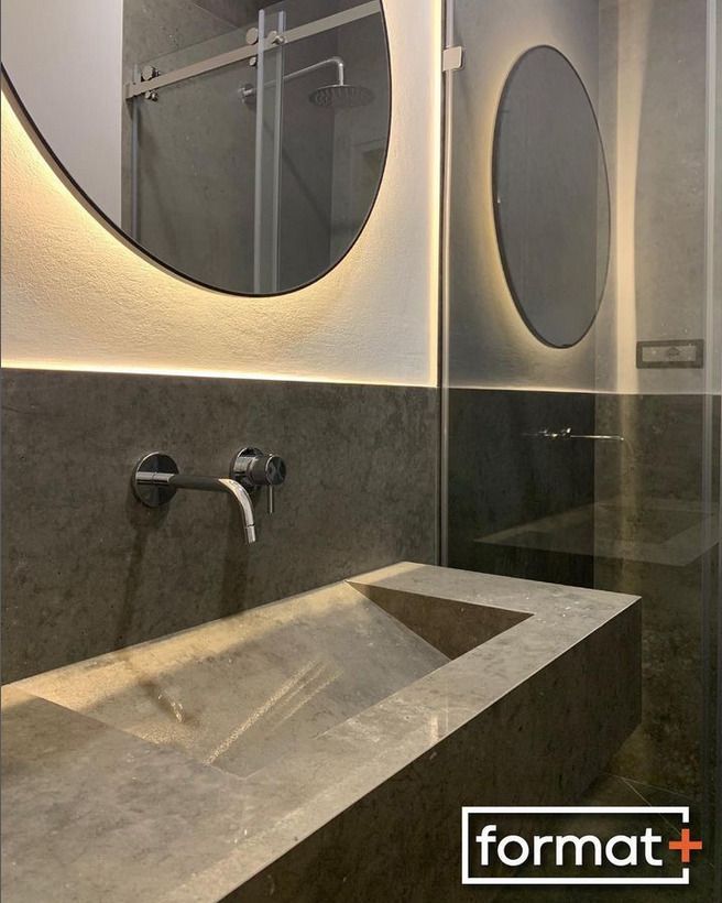 A modern bathroom with a minimalist concrete sink, wall-mounted mirror, and streamlined fixtures, emphasizing a raw, industrA modern bathroom with a minimalist concrete sink, wall-mounted mirror, and streamlined fixtures, emphasizing a raw, industrial aesthetic.ial aesthetic.