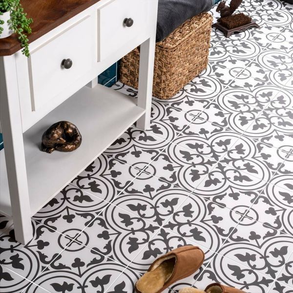 Black patterned floor tiles below a cupboard
