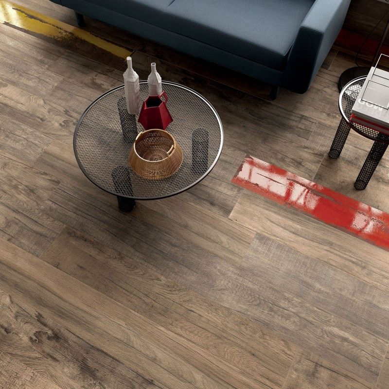 Close up of wooden effect floor tiles and a black table with pots ontop