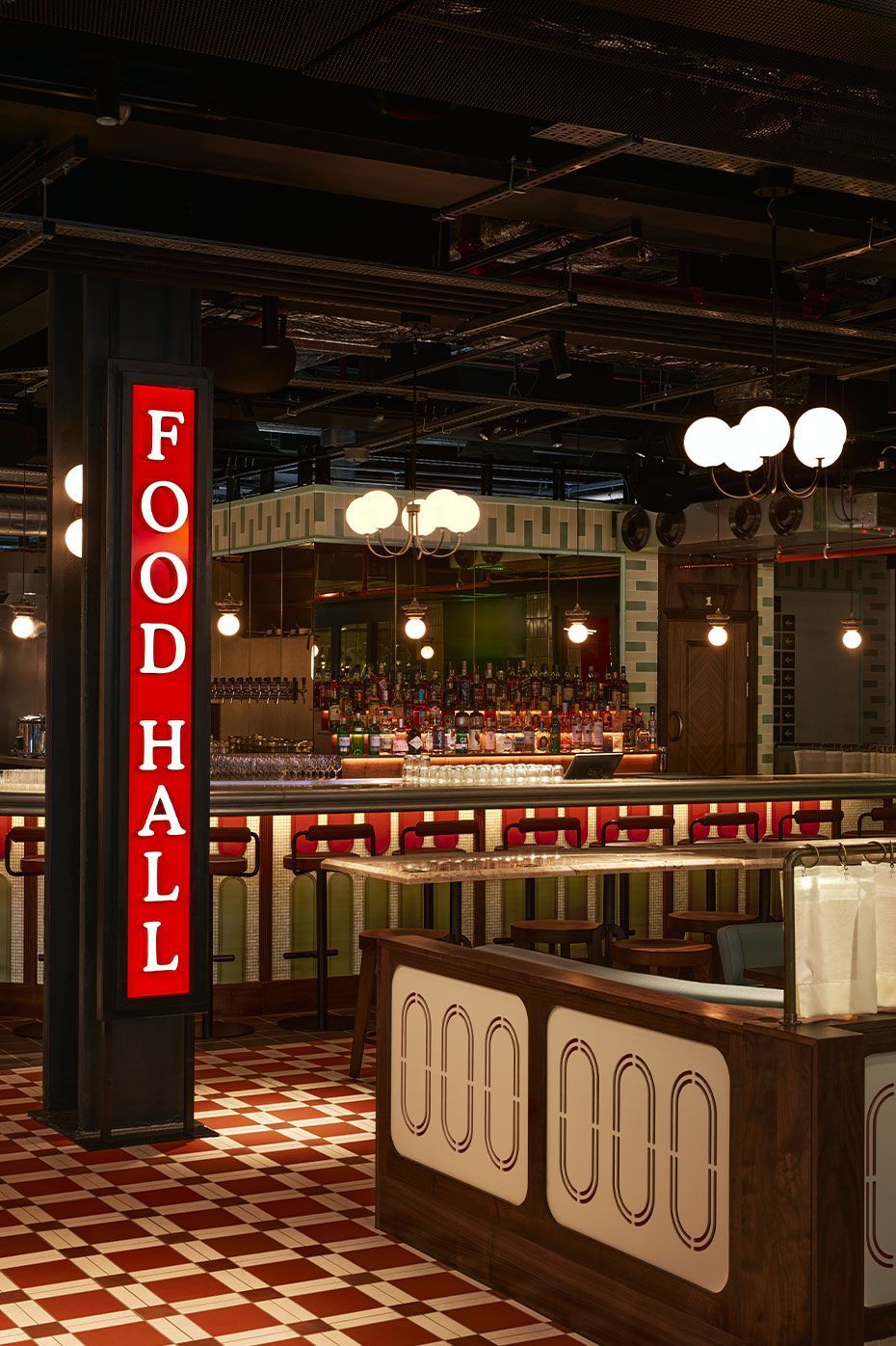 a food hall sign in big red writing and lights hanging from the ceeling