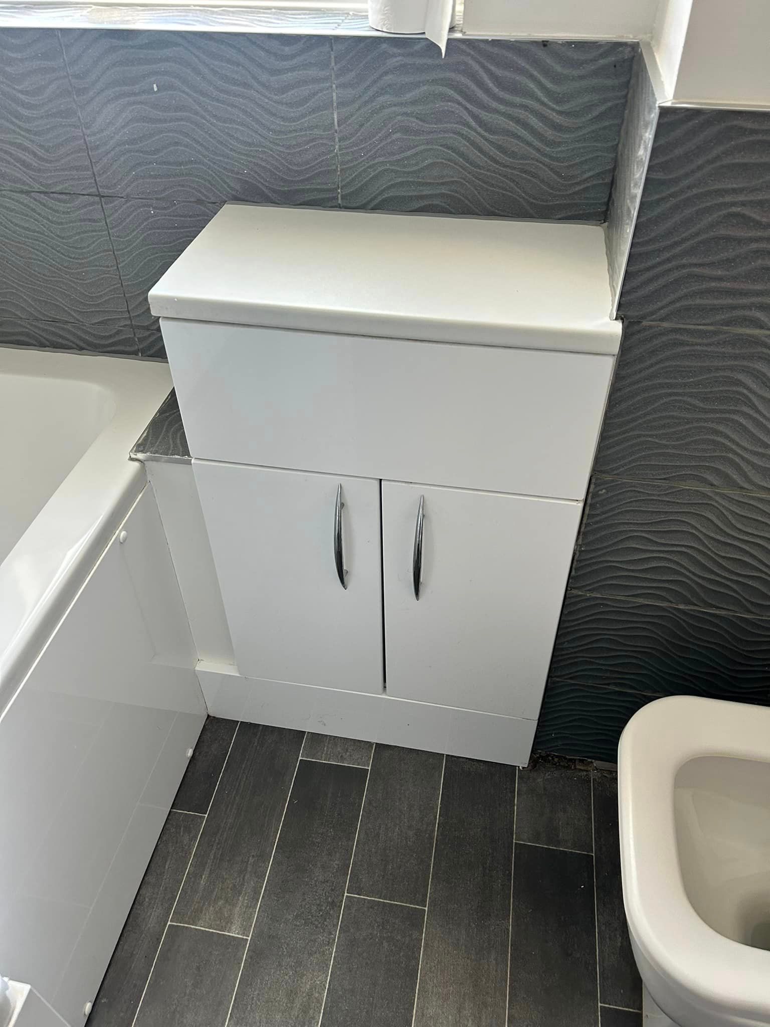 Close up of a bath and cupboard