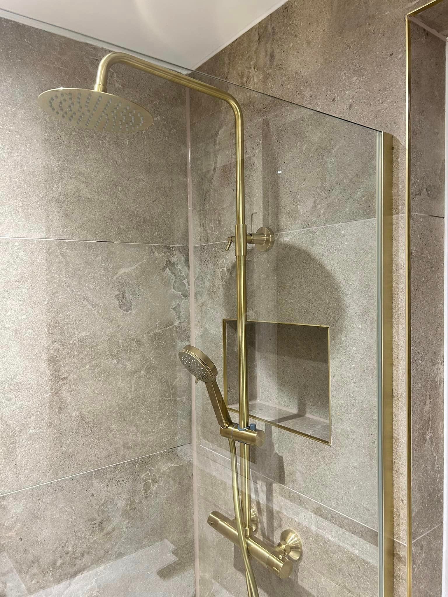 Free standing shower tiled with limestone effect tiles