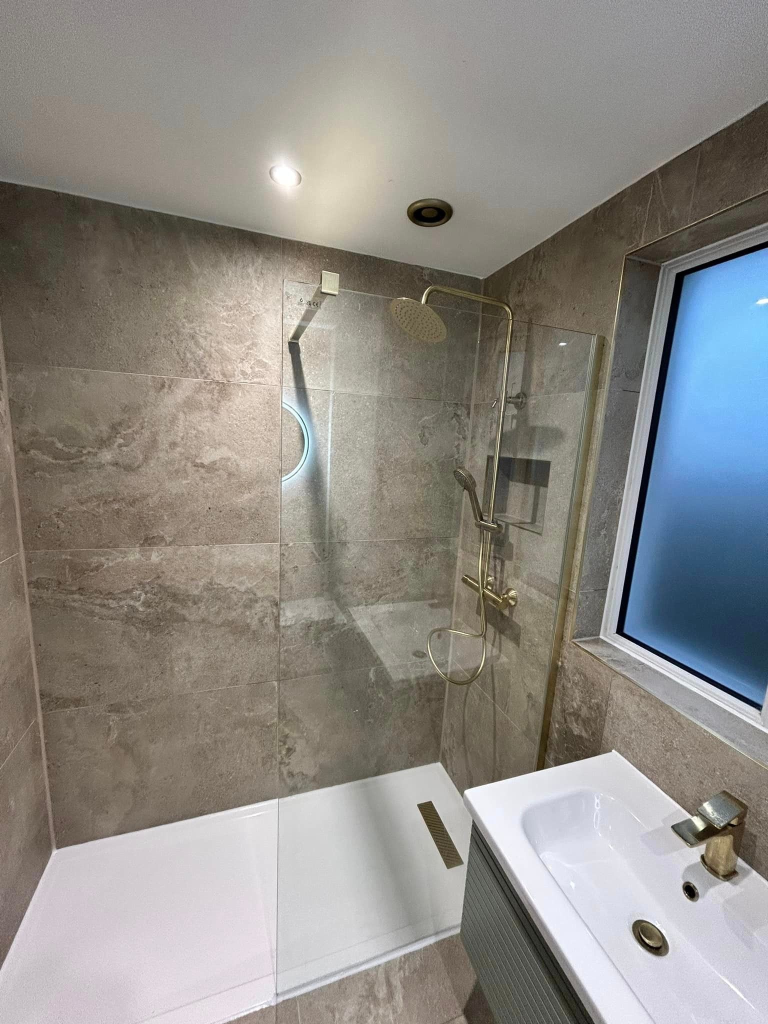 Bath shower with beige limestone effect wall tiles in a 90x60 format