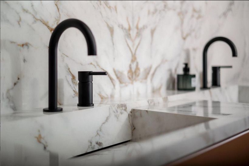 Marble effect public bathroom with a marble feature wall splashback with bespoke marble sinks