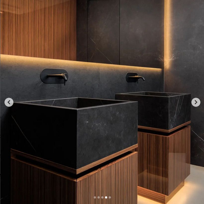 2 black featured bespoke marble sinks in a public bathroom