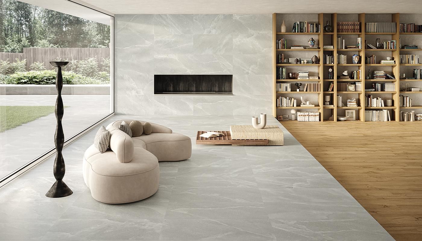 Grey floor and wall tile with black lamp and cream coloured couch