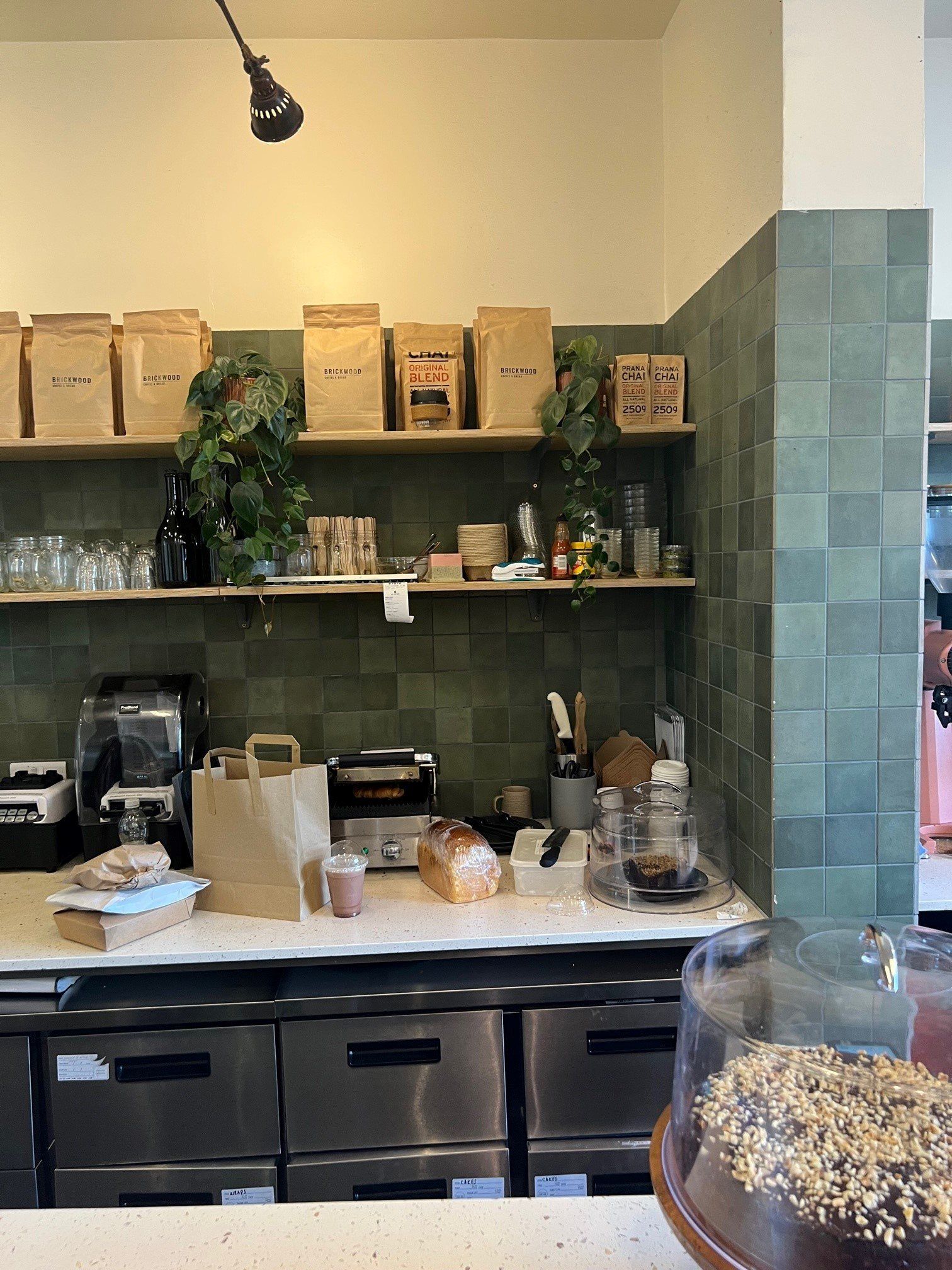 behind the scenes of a cafe with green square wall tiles