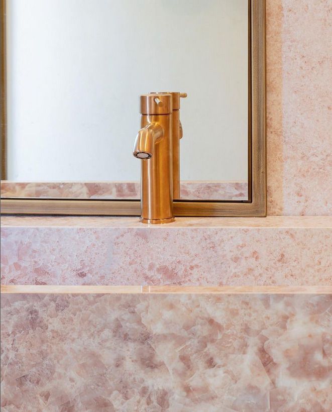 Terrazzo pink sink close up with golden brassware tap