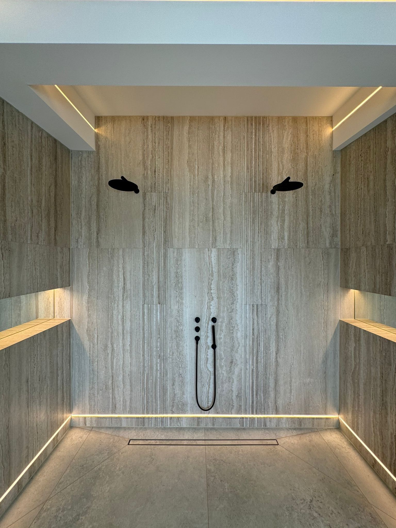 Travertine wall tiles used in a shower with 2 shower heads