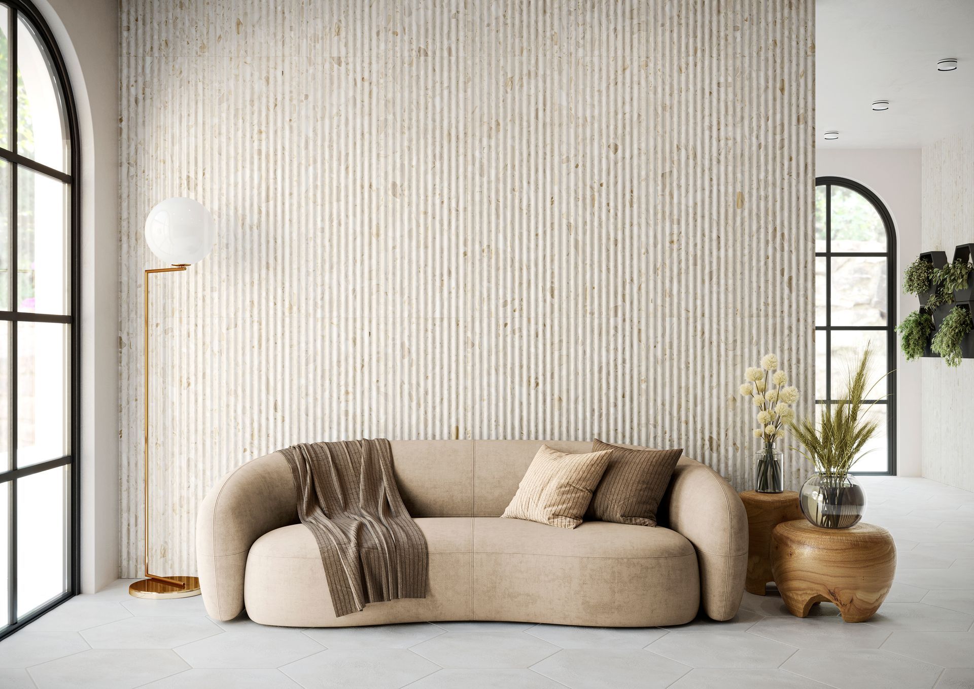 A cozy living room with a large beige fluted terrazzo feature wall, soft curved sofa, and wooden side tables. Neutral tones and natural lighting create a calming, minimalist ambiance.