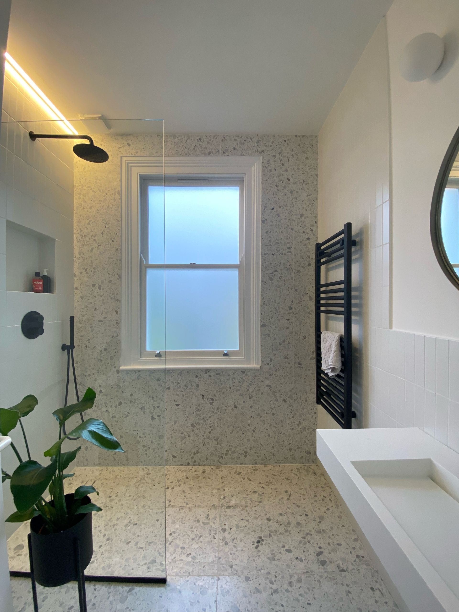 window and a bathrooms towel ral with terrazzo effect tiles