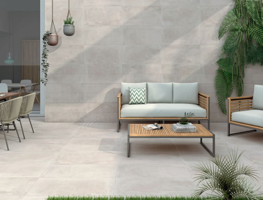 concrete floor tiles outside on a smaller patio with a baby blue couch