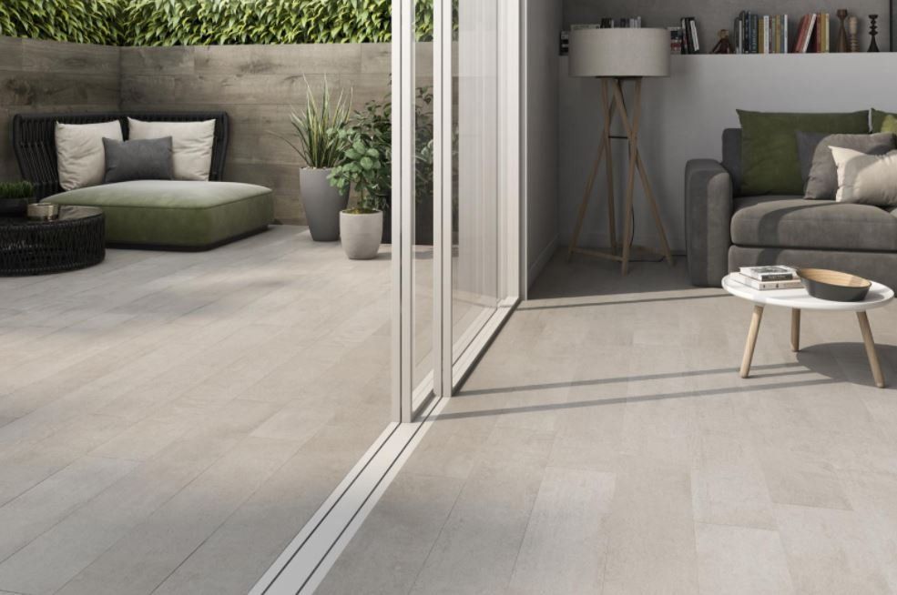concrete floor tiles , a seamless bifold patio door with outdoor and indoor tiles