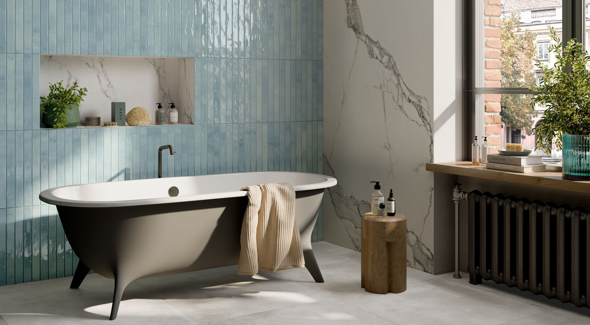 blue brick tiles used in a bathroom , a modern grey bathtub with a marble accent wall and a black bathtub tao and a big window