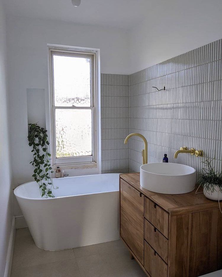 White kit kat wall tiles used in a bathroom and golden brass taps