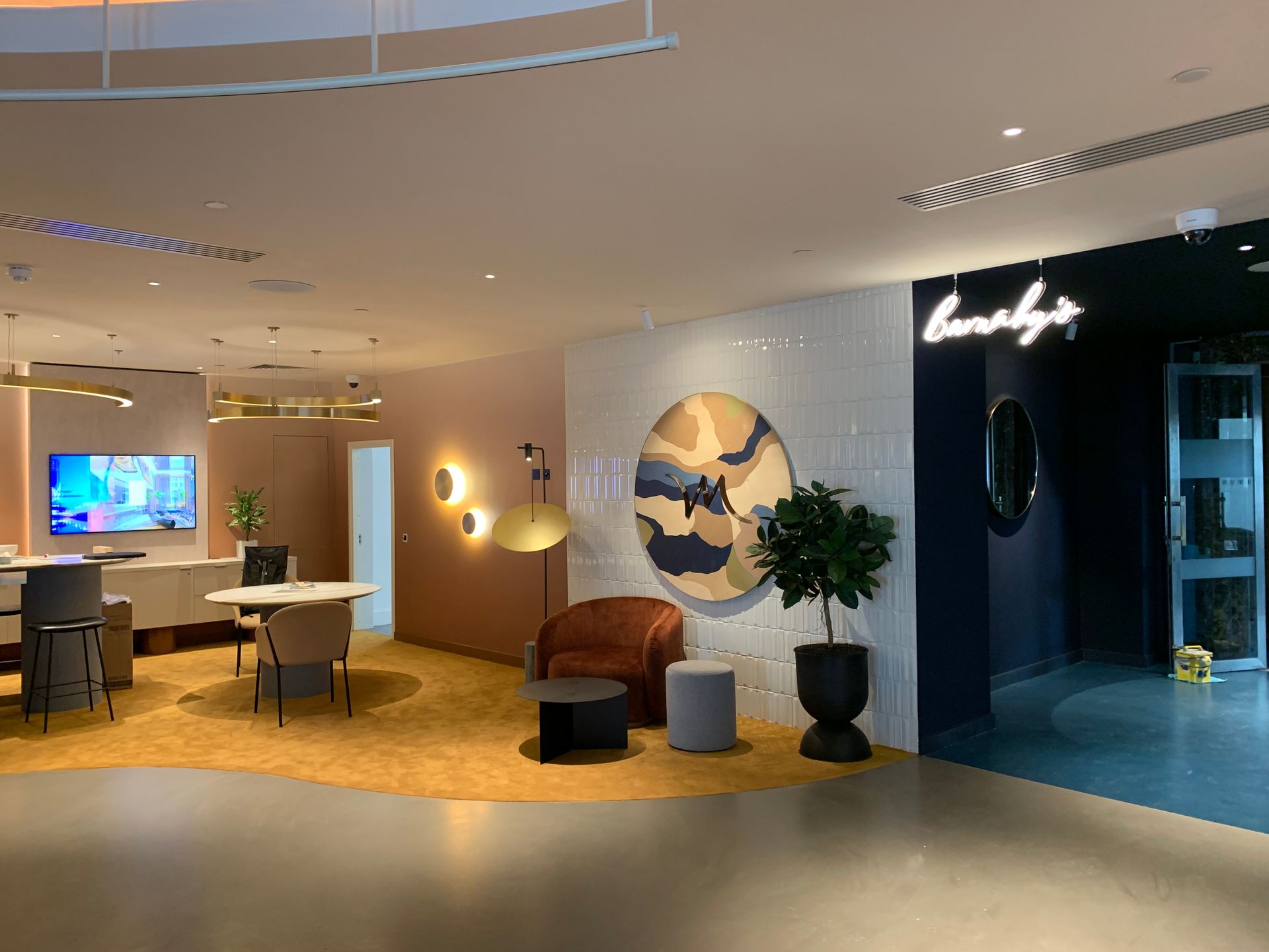 Chairs and table infront of the Flaut Blanco featured wall in this office area