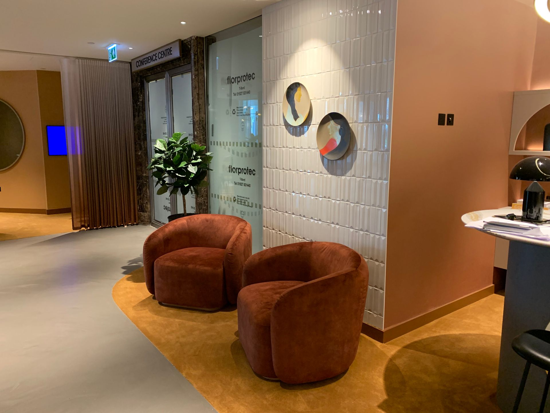 2 orange chairs infront of Flaut Blanco gloss on a featured wall in the office